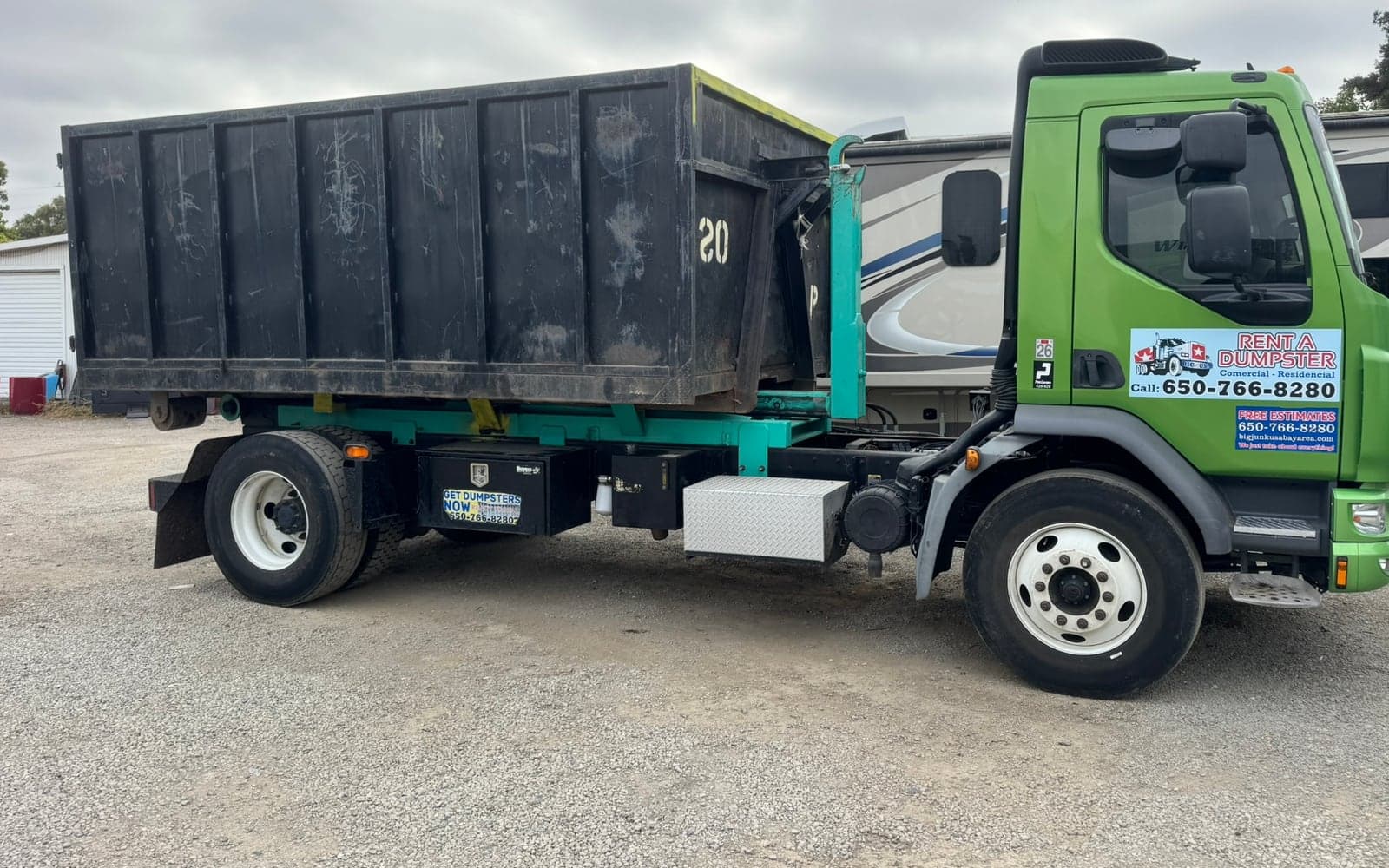 A Big Junk USA roll-off box on the truck, ready to set down